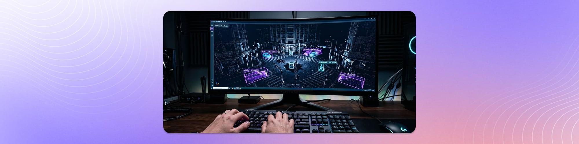 Hands typing at a keyboard beside a monitor showing a 3D point cloud of a city street with highlighted objects and annotation bounding boxes.